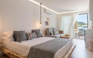 a bedroom with a large bed and a living room at Michalakis Seaside Suites in Pollonia
