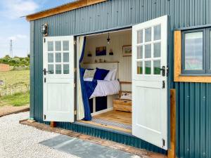 a blue shed with a bed inside of it at Walkeridge Farm in Reading