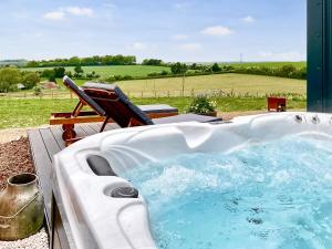 a jacuzzi tub with a chair in a field at Walkeridge Farm in Reading