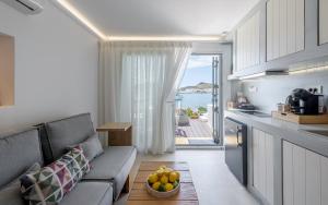 a living room with a couch and a table with a bowl of fruit at Michalakis Seaside Suites in Pollonia