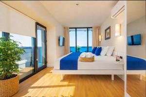 a bedroom with a bed with blue and white pillows at Panorama ORBI CITY LUXURY in Batumi