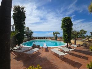 a swimming pool with chaise lounge chairs and a swimming pool at Villa Timea Piscina e Tennis Vista Isole Egadi in Marsala