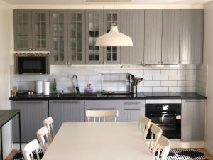a kitchen with a white table and chairs at Mysiga Villan in Borgholm