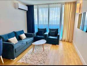 a living room with a blue couch and two chairs at Panorama ORBI CITY LUXURY in Batumi +132 photos