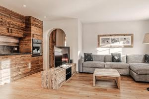 a living room with a couch and a tv at Alpslodge - Amelia in Arosa