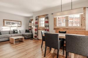 a living room with a table and a couch at Alpslodge - Amelia in Arosa