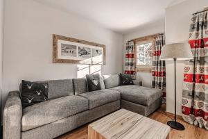 a living room with a couch and a table at Alpslodge - Amelia in Arosa