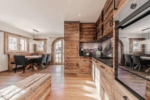 a kitchen with wooden walls and a dining room at Alpslodge - Amelia in Arosa +6 photos