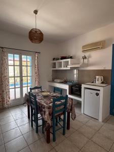 a kitchen with a table and chairs in a room at Kapetan Sorokos Studios 2 in Koufonisia
