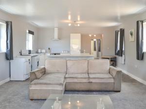 a living room with a couch and a kitchen at Dotterel Cottage - Uk39264 in Reighton