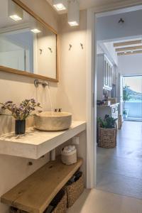 a bathroom with a sink and a mirror at Michalakis Seaside Suites in Pollonia +62 photos