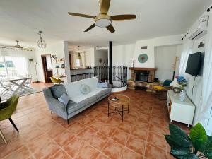 a living room with a couch and a ceiling fan at Villa El Dorado in Estepona