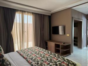 a hotel room with a bed and a television at RS Hôtel Karam Resort in Ouarzazate