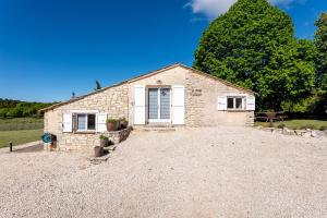 a stone house with a gravel driveway at La Grange D'anthounin in Redortiers