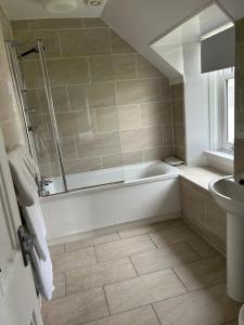 a bathroom with a tub and a sink at Loch Ness Guest House in Fort Augustus +31 photos