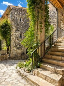 an old stone building with stairs in front of it at Hôtel restaurant Clos des Sullys in Montclus