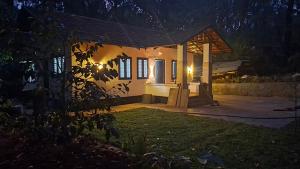 a house with a lit up yard at night at Mausam Homestay in Sultan Bathery