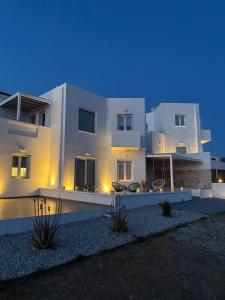 a large white house at night with lights at Eolia luxury suites Andros in Batsi