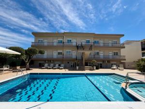 a hotel with a swimming pool in front of a building at Brother's House in Kallithea Halkidikis