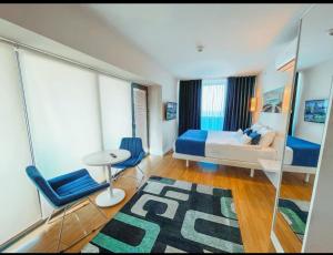a bedroom with a bed and a table and chairs at Panorama ORBI CITY LUXURY in Batumi