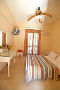 a bedroom with a bed and a ceiling fan at Adriana Studios in Perivólion