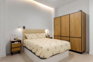 a bedroom with a large bed and a wooden cabinet at La casa del Pan in Málaga