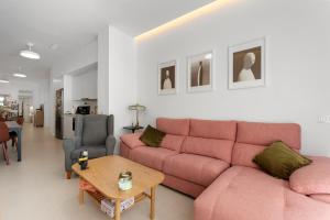 a living room with a pink couch and a table at La casa del Pan in Málaga