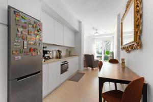 a kitchen with a stainless steel refrigerator and a table at La casa del Pan in Málaga