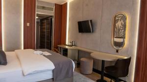 a hotel room with a bed and a desk at Plaza Hotel Diyarbakir in Diyarbakır