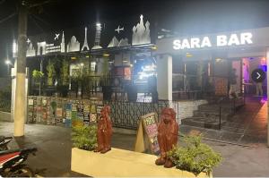 two statues in front of a sara bar at night at casa de esteban in Puerto Iguazú