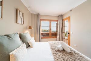 a bedroom with a white bed with a window at CARABELA 92 in Alcudia +9 photos