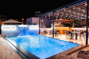 a large swimming pool with a table and chairs at Erik Studio in Ksamil