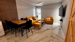 ein Wohnzimmer mit einem Tisch und einem gelben Sofa in der Unterkunft Bydgoszcz GOLD 7 z sypialnią in Bydgoszcz