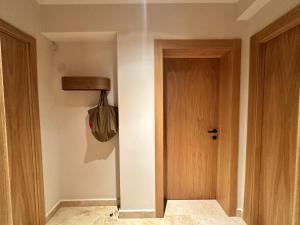 a hallway with a wooden door and a bag at Hotel Carmen in Eforie Nord
