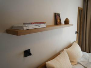 two books sitting on a shelf above a bed at Hotel Carmen in Eforie Nord