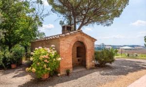 a brick building with a fireplace in a yard at Holiday al Poggettone in Monteroni dʼArbia