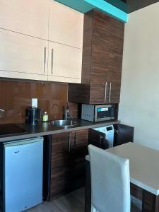 a kitchen with wooden cabinets and a counter top at Orbi Residence in Itʼkhvisi