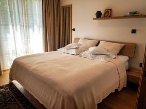 a bedroom with a large bed with white sheets and a window at Hotel Carmen in Eforie Nord