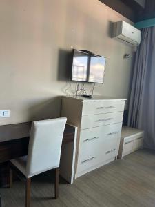 a desk with a white dresser and a white chair at Orbi Residence in Itʼkhvisi