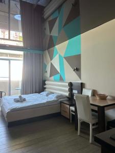 a bedroom with a bed and a desk with a computer at Orbi Residence in Itʼkhvisi