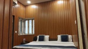 a bedroom with a large bed in a wooden wall at hotel sooryoday j in Varanasi