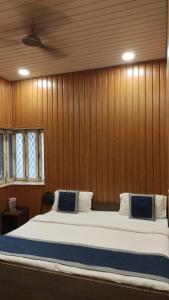 a bedroom with a large bed with wooden walls at hotel sooryoday j in Varanasi