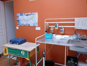 an orange room with a table and a sink at L'atelier du vélo in Sully-sur-Loire