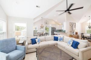 a living room with a white couch and blue pillows at Oceanside retreat with pool & spa June Weeks Open in Sanderling +60 photos