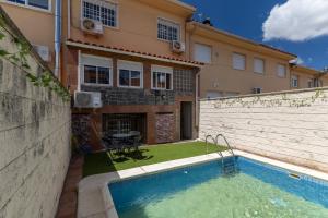 a house with a swimming pool in front of a building at Semi-detached Hse in Loeches