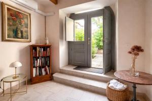 a room with a door and a table and a book shelf at Aurisina residence in Aurisina