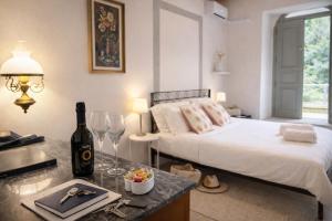 a bedroom with a bed and a table with a bottle of wine at Aurisina residence in Aurisina