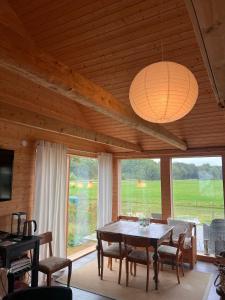 a dining room with a table and some windows at Bergsbo Lodge in Halmstad