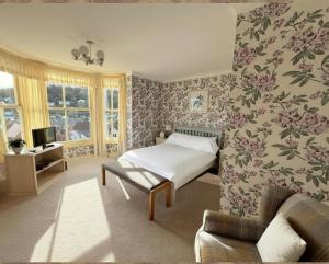 a bedroom with a bed and floral wallpaper at Ingleside in Lynton