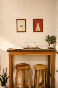 a wooden bar with two stools and two pictures on the wall at Pahuway - Comfort and style in Moalboal